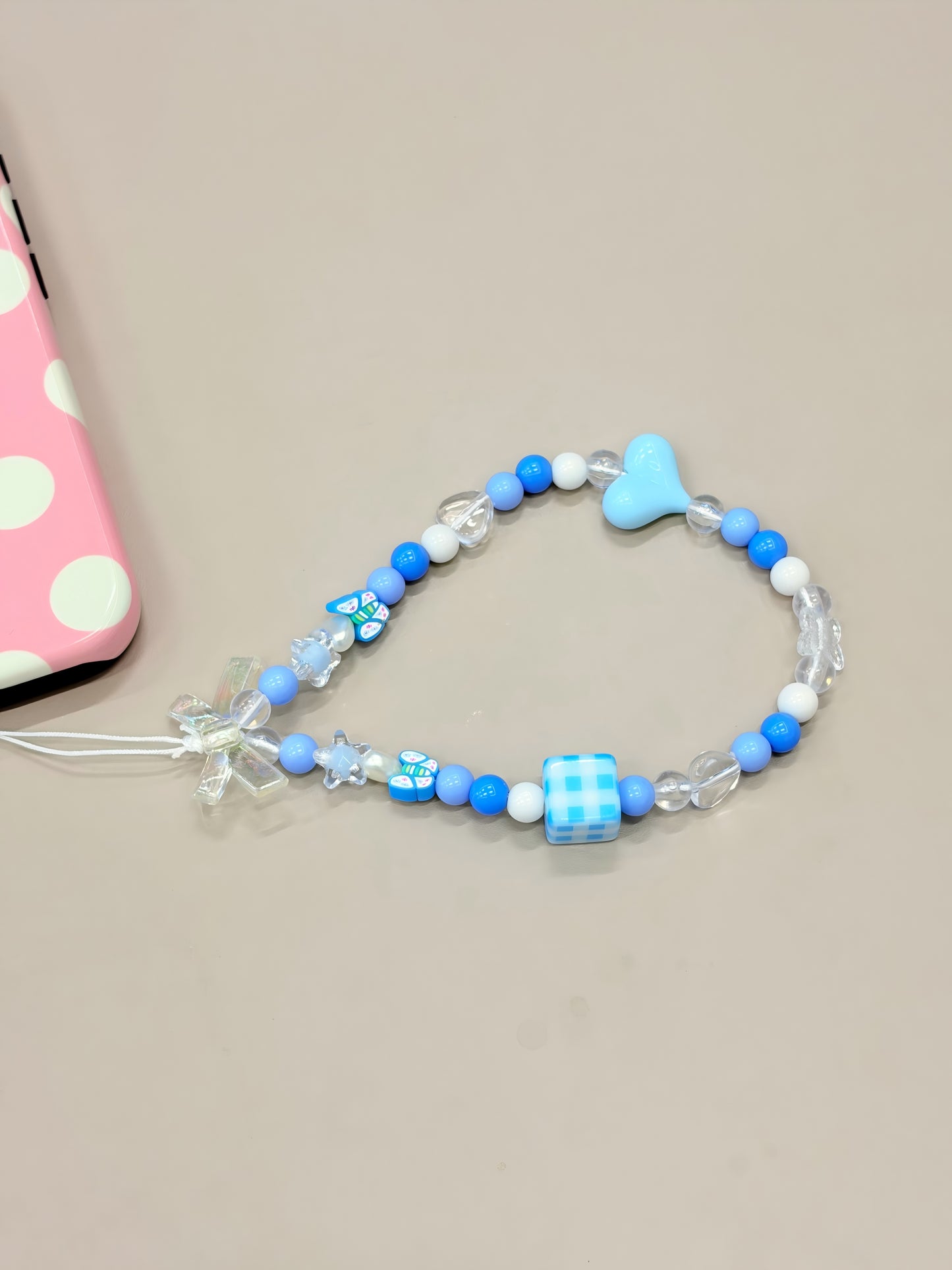 Heart beaded phone strap attached to mobile phone case