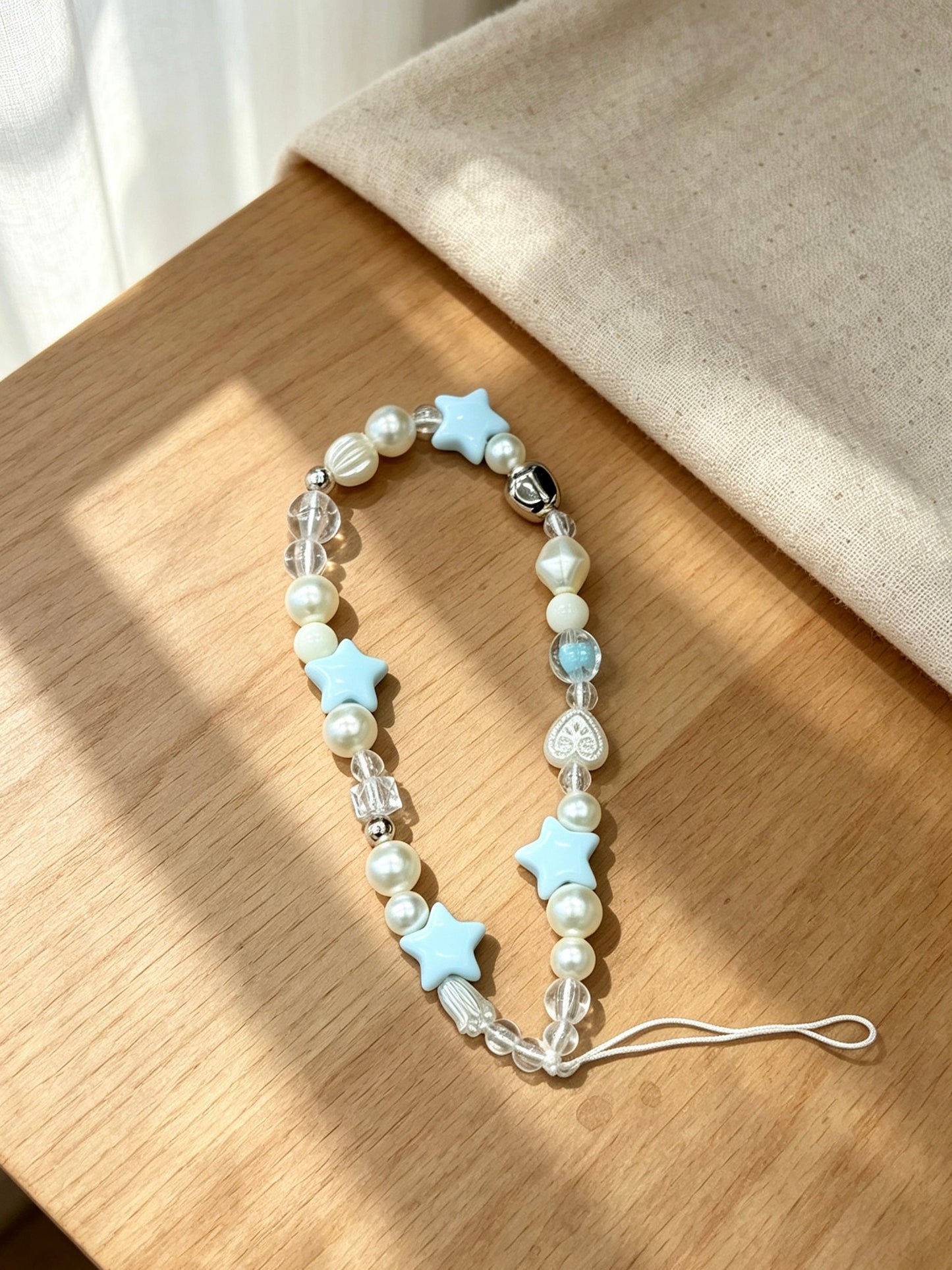 Star beaded phone wrist strap with decorative charm design