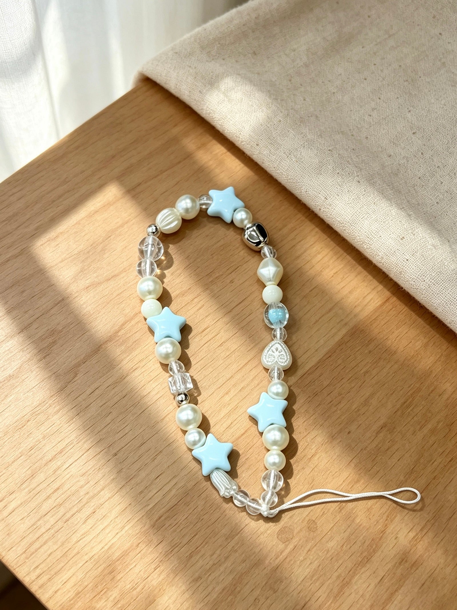 Star beaded phone wrist strap with decorative charm design